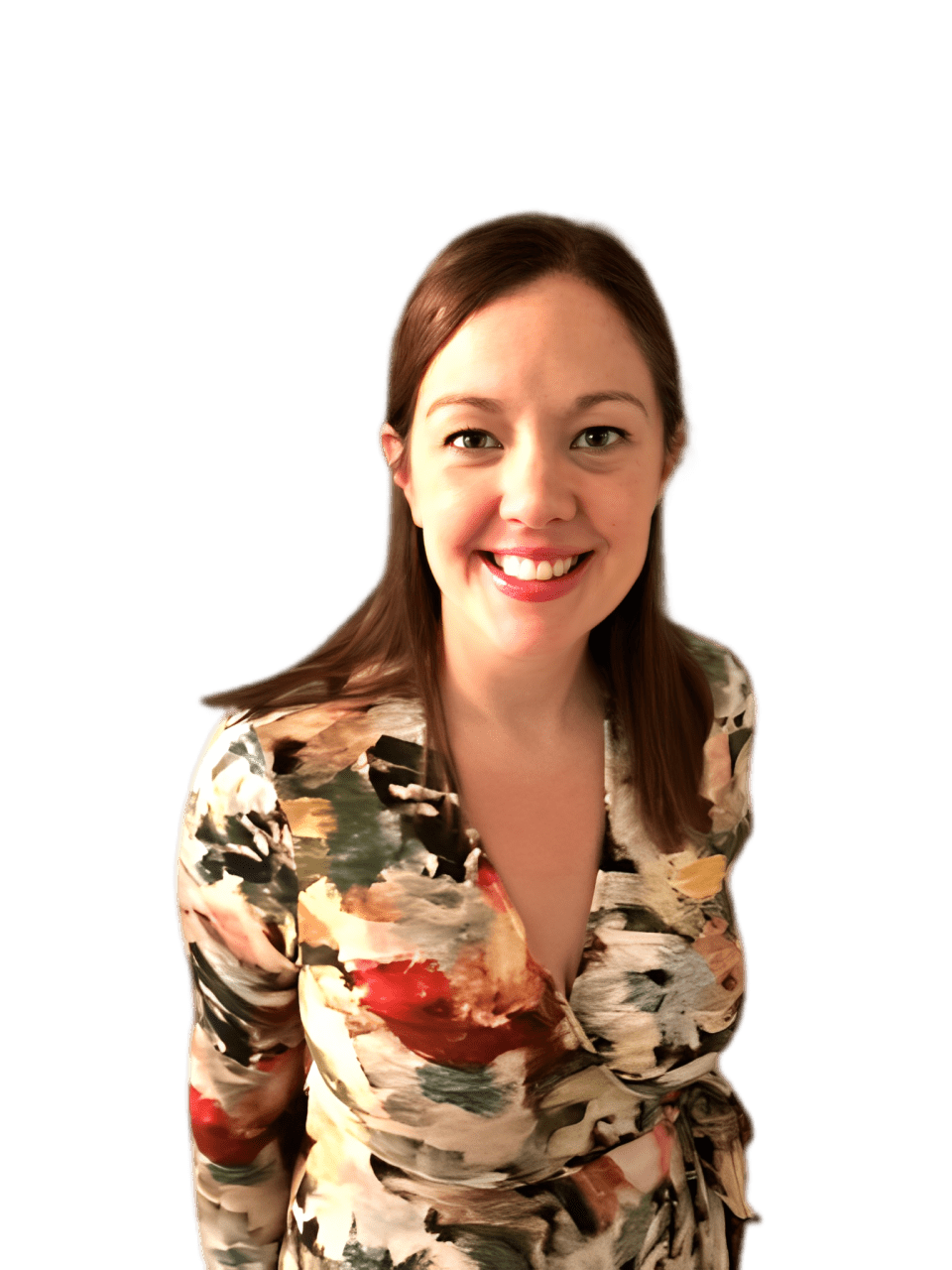 Smiling Woman in a Colorful Floral Dress Stands in Front of a Gray Wall, Conveying a Friendly and Approachable Demeanor.